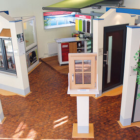 Ausstellung mit modernen Fenstern und Haustüren aus Holz und Kunststoff in einem Showroom.